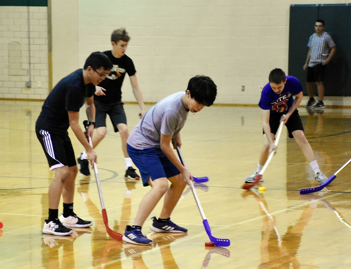 Floor hockey in PE class Lincoln Pius X Catholic High School